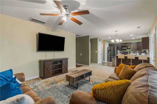 living area with baseboards, ceiling fan with notable chandelier, visible vents, and recessed lighting