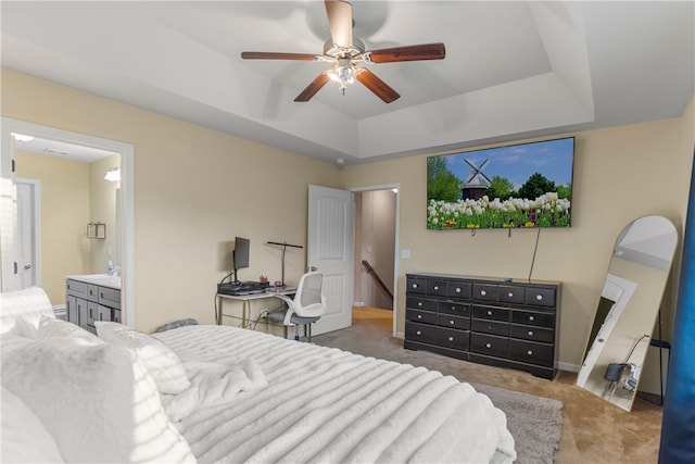 bedroom featuring ceiling fan, connected bathroom, carpet flooring, baseboards, and a raised ceiling