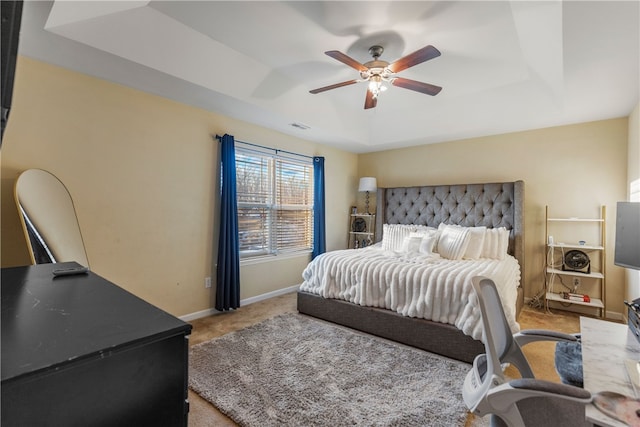 bedroom with baseboards, visible vents, ceiling fan, a tray ceiling, and carpet flooring