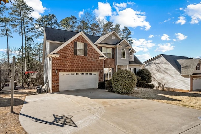 traditional-style house featuring driveway, an attached garage, and brick siding