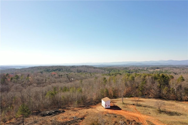 birds eye view of property with a wooded view and a mountain view