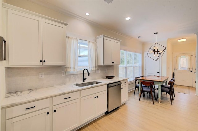 kitchen with a sink, white cabinetry, ornamental molding, stainless steel dishwasher, and light wood finished floors