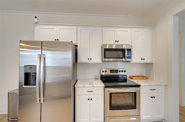 kitchen with stainless steel appliances, decorative backsplash, ornamental molding, white cabinets, and light stone countertops