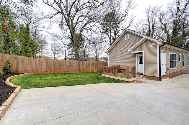 back of property featuring a deck, a patio, a yard, and a fenced backyard