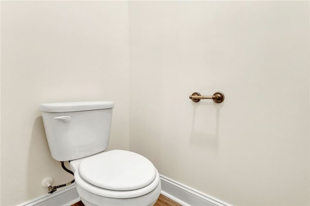 bathroom featuring wood finished floors, toilet, and baseboards