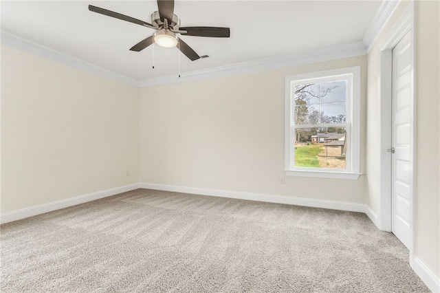 carpeted spare room featuring crown molding, baseboards, and ceiling fan