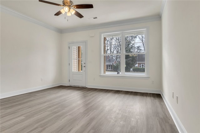 empty room featuring visible vents, crown molding, and wood finished floors