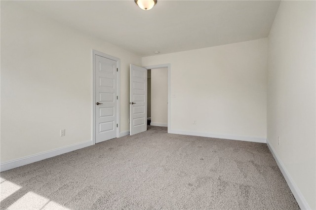 carpeted spare room with baseboards