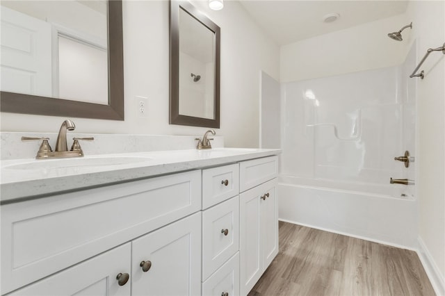 full bathroom featuring shower / bathtub combination, double vanity, wood finished floors, and a sink