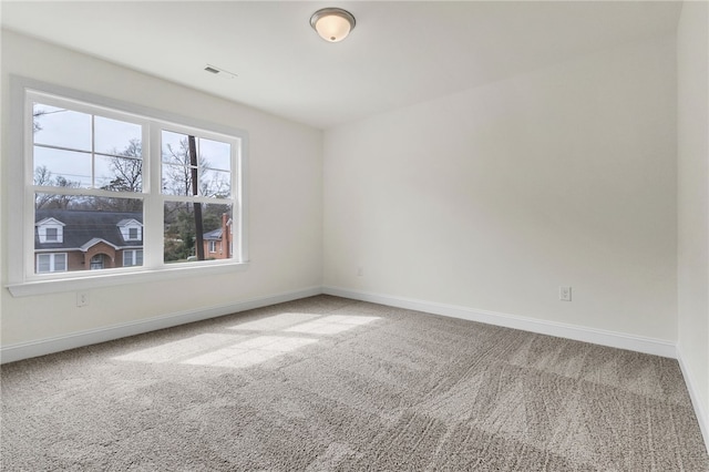 carpeted spare room featuring baseboards and visible vents