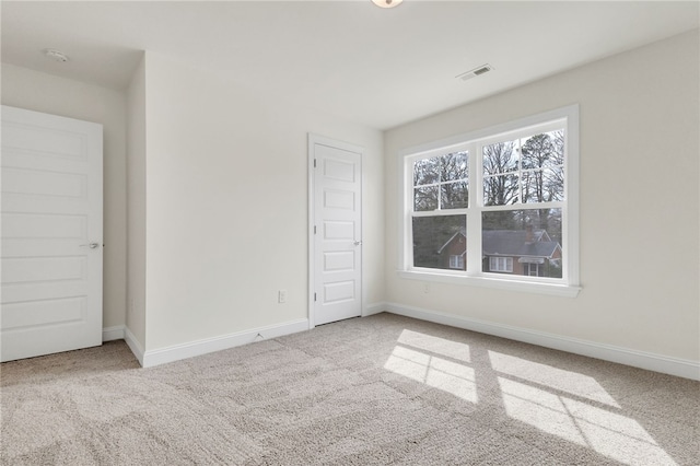 unfurnished bedroom with carpet floors, baseboards, and visible vents