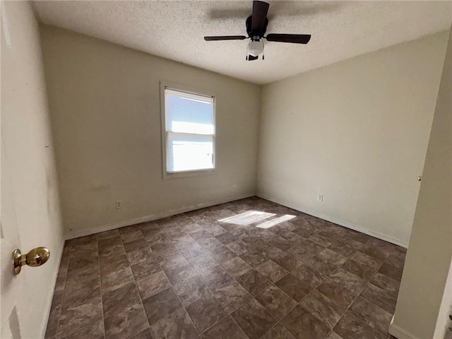 unfurnished room featuring ceiling fan, a textured ceiling, and baseboards