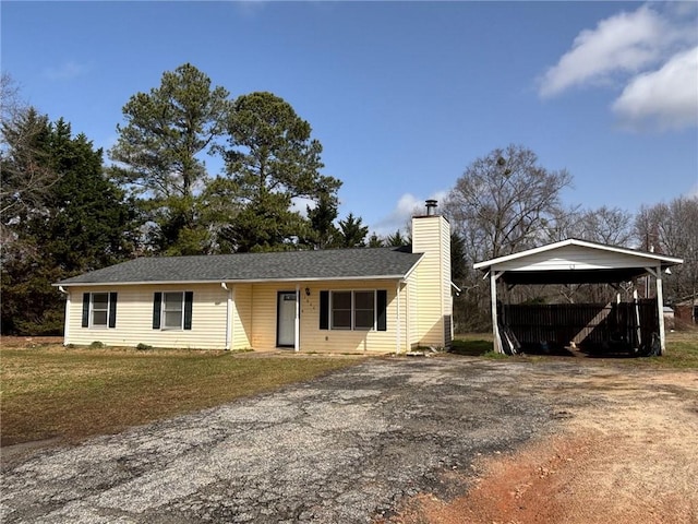 single story home with dirt driveway, a chimney, a front lawn, and a carport