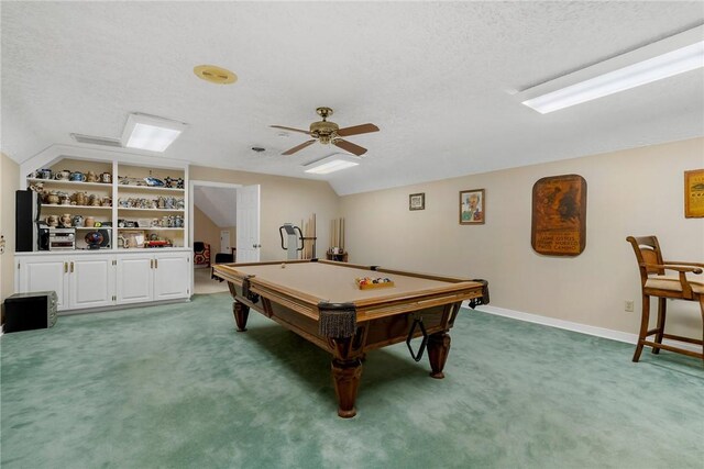 rec room featuring a textured ceiling, light colored carpet, a ceiling fan, baseboards, and vaulted ceiling