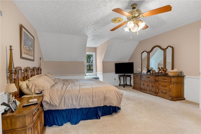 bedroom featuring a textured ceiling, ceiling fan, carpet, and lofted ceiling