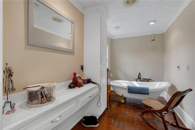 full bath featuring brick floor, a freestanding tub, crown molding, and a textured ceiling