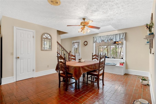 dining space with brick floor, stairway, baseboards, and a ceiling fan