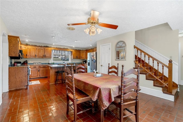 dining room with brick floor, baseboards, stairway, and a ceiling fan