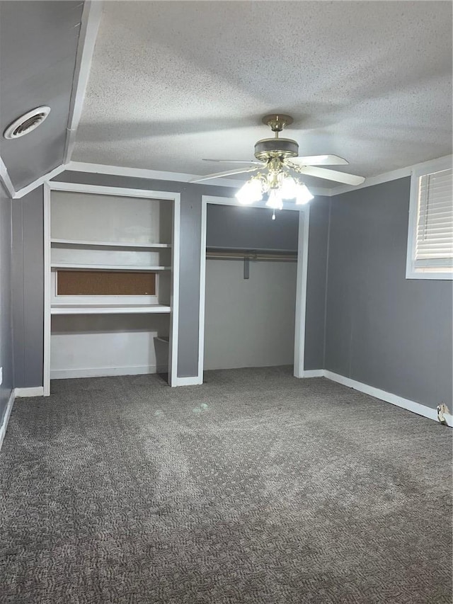 unfurnished bedroom with carpet, two closets, visible vents, a ceiling fan, and a textured ceiling