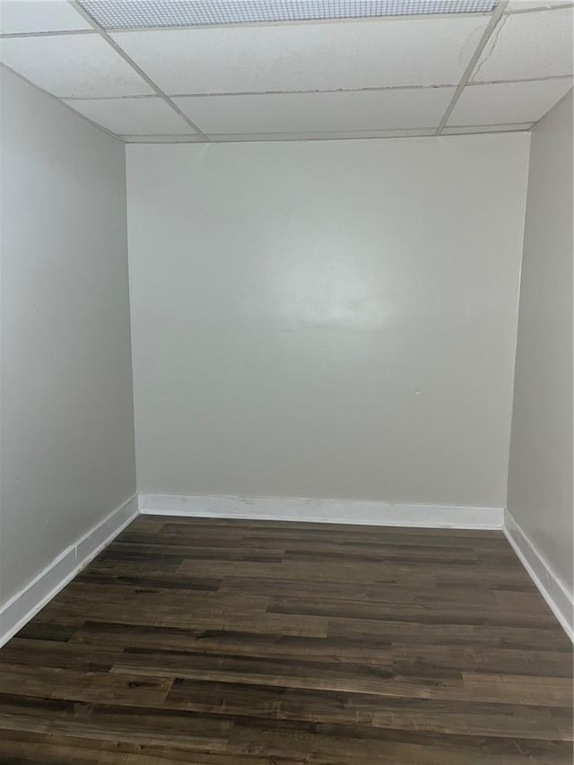 spare room with dark wood-style floors, a paneled ceiling, and baseboards