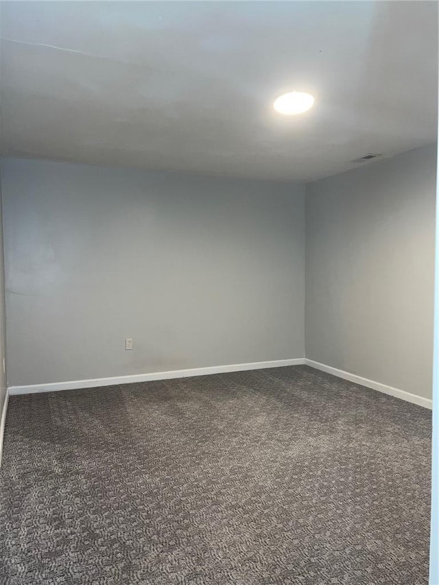 spare room with carpet, visible vents, and baseboards