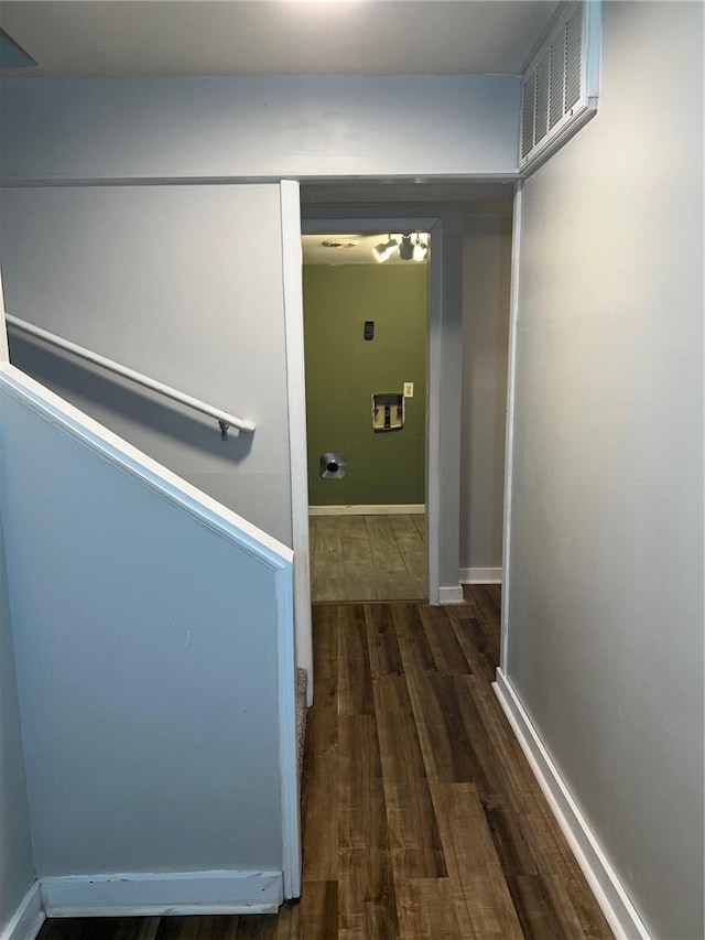 hallway featuring visible vents, baseboards, and wood finished floors