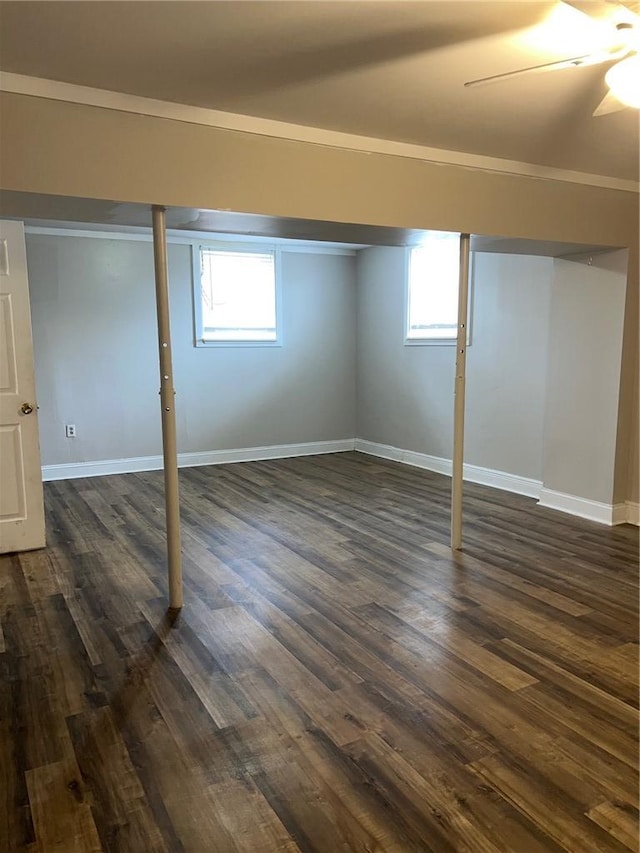 basement with plenty of natural light, baseboards, and dark wood finished floors