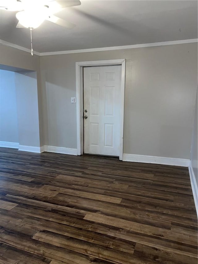 empty room with ceiling fan, baseboards, dark wood finished floors, and crown molding