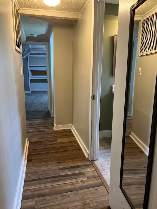 hallway featuring dark wood finished floors and baseboards