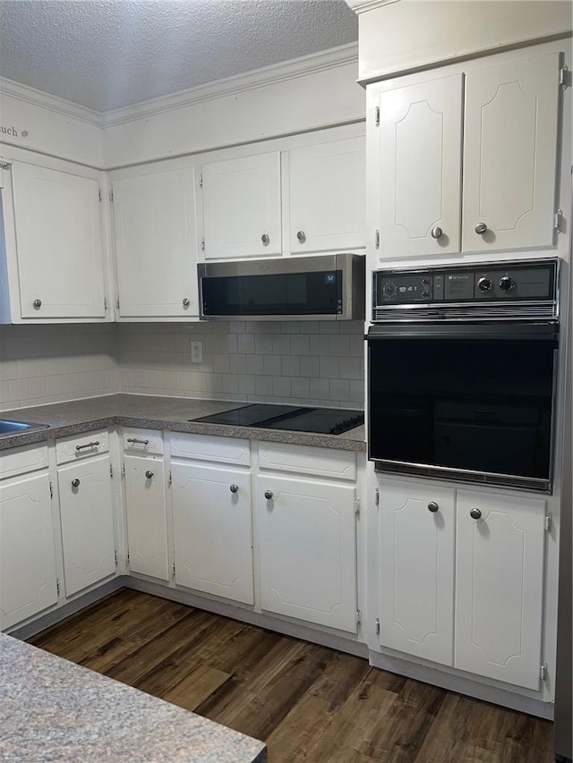 kitchen featuring black appliances, dark wood-style flooring, and white cabinets