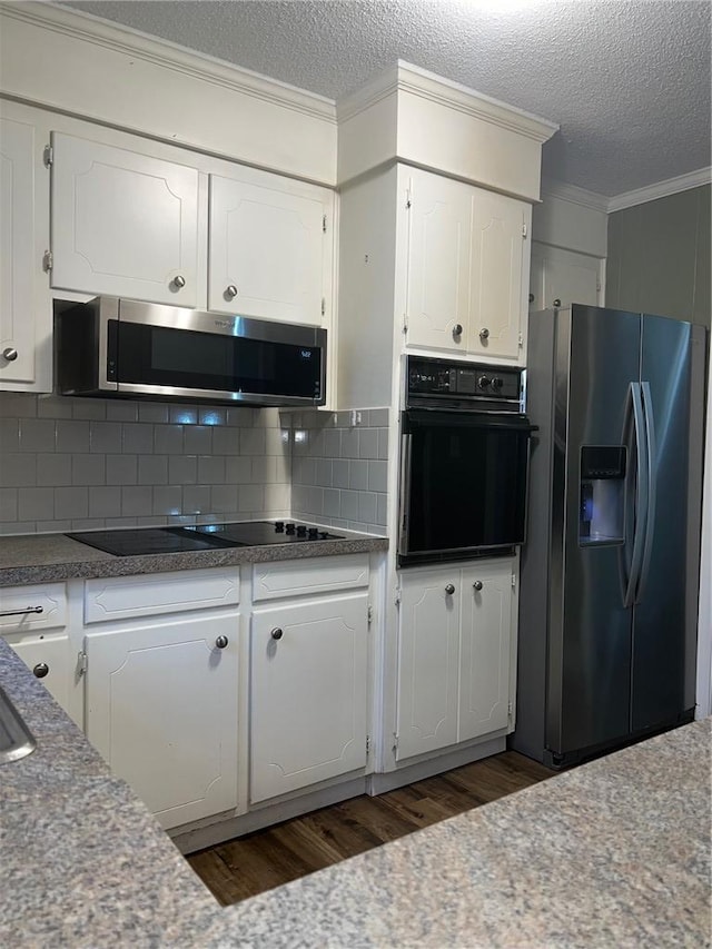 kitchen with crown molding, decorative backsplash, dark wood-type flooring, white cabinetry, and black appliances