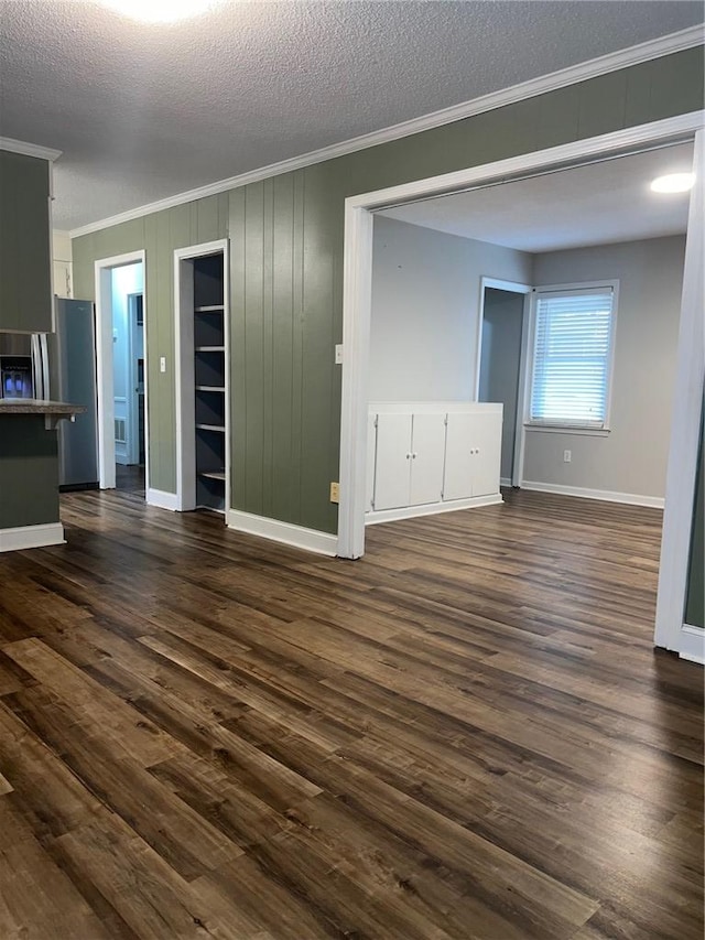 interior space with dark wood-style floors, a textured ceiling, and crown molding