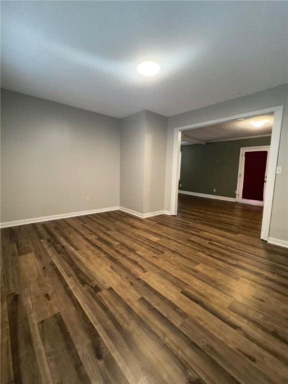 empty room featuring dark wood-style floors and baseboards