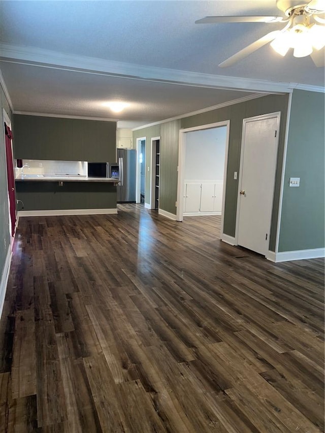 unfurnished living room featuring ceiling fan, ornamental molding, dark wood-style flooring, and baseboards