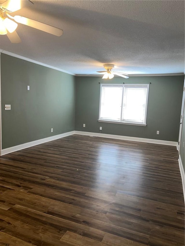 spare room featuring ornamental molding, dark wood-style flooring, a ceiling fan, and baseboards