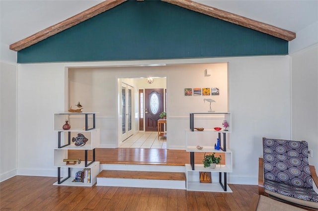 entryway featuring hardwood / wood-style flooring, baseboards, and vaulted ceiling