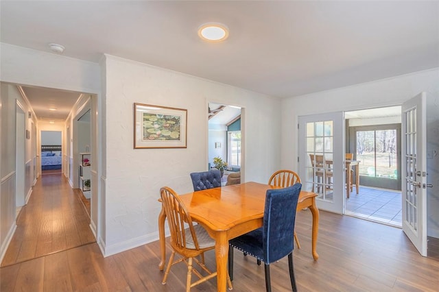 dining room with french doors, baseboards, and wood finished floors