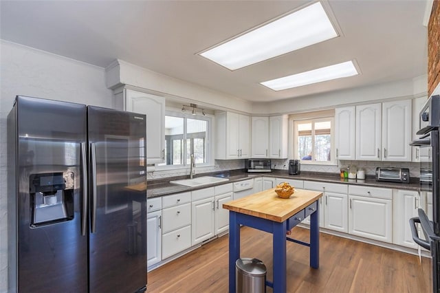 kitchen with a healthy amount of sunlight, white cabinetry, a sink, and stainless steel fridge with ice dispenser