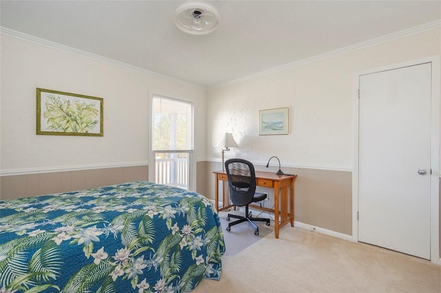 carpeted bedroom featuring ornamental molding and wainscoting