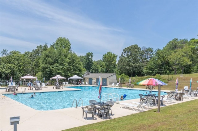 pool featuring a patio area, a gazebo, fence, and a yard