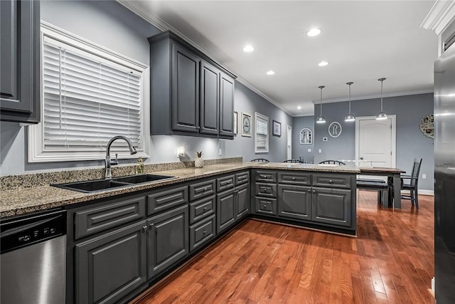 kitchen featuring a peninsula, a sink, ornamental molding, stainless steel dishwasher, and dark wood-style floors