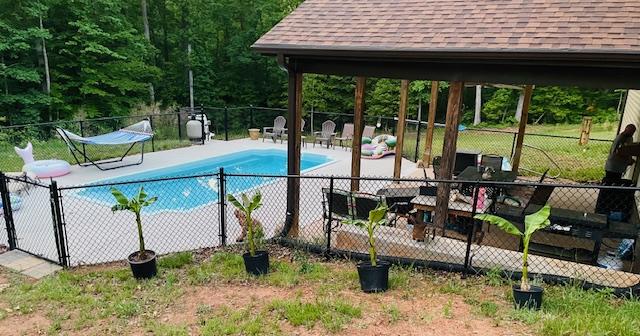 view of pool featuring a patio, fence, and a fenced in pool