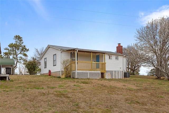 back of property featuring a yard, a chimney, covered porch, metal roof, and cooling unit