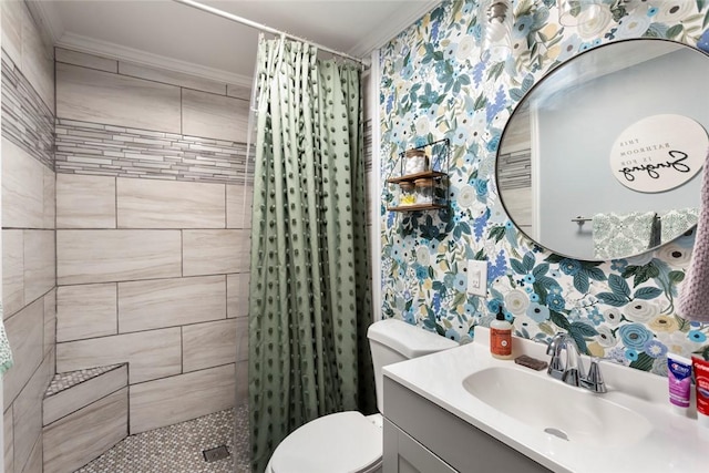 bathroom featuring toilet, vanity, ornamental molding, a tile shower, and wallpapered walls