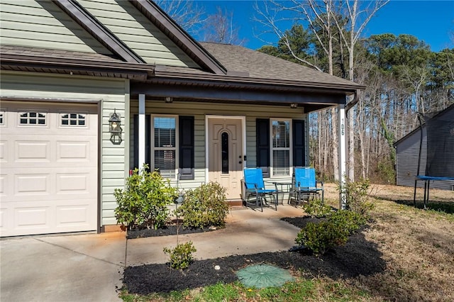 property entrance with covered porch, a shingled roof, and a garage