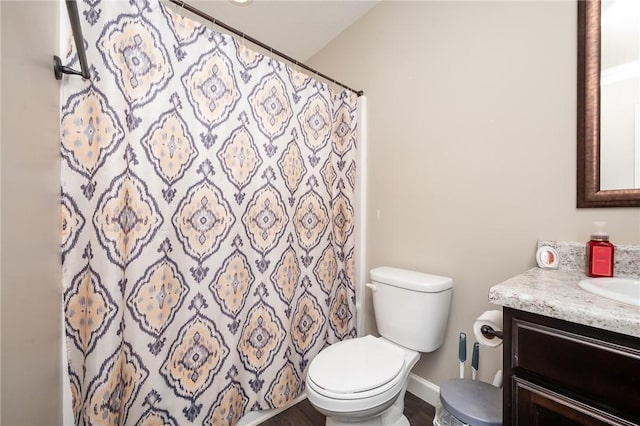 full bath featuring a shower with shower curtain, vanity, toilet, and baseboards