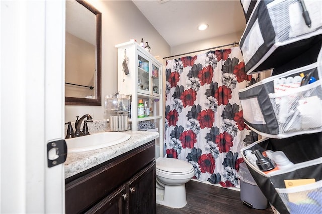 bathroom with toilet, recessed lighting, wood finished floors, vanity, and a shower with curtain