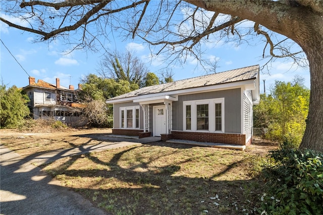 view of front of property with brick siding and metal roof