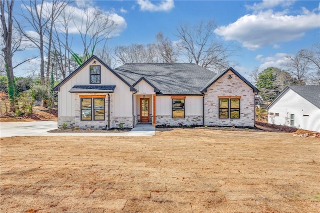 modern inspired farmhouse featuring stone siding, a front lawn, and board and batten siding