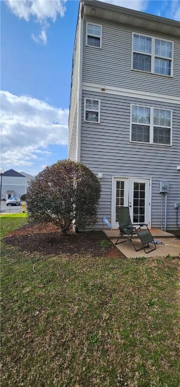 rear view of property with a patio area and a lawn